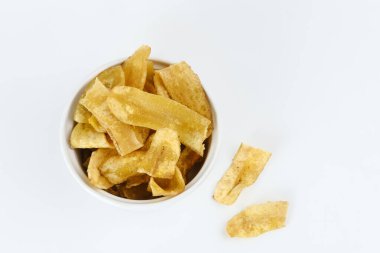 Beyaz arka planda bir yığın kurutulmuş muz cipsi. Seçici odak resmi, bulanık arkaplan.