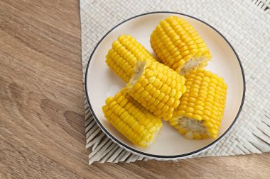 Jagung Manis Rebus ya da tahtadan arka planda servis edilen kasede kaynatılmış mısır dilimleri. Metin için boşluk. 