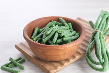 Uzun fasulye ya da Kacang Panjang ahşap kasede servis edilir, yemek hazırlanır..