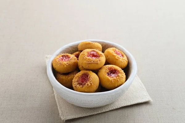 Thumb print cookies filled with strawberry jam and grated cheese. Familiar during the month of Ramadan and Eid Fitri.