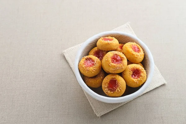 Thumb print cookies filled with strawberry jam and grated cheese. Familiar during the month of Ramadan and Eid Fitri.