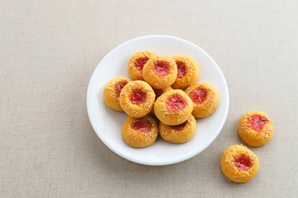 Thumb print cookies filled with strawberry jam and grated cheese. Familiar during the month of Ramadan and Eid Fitri.