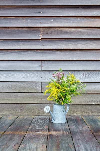 Tahta bir duvarın önündeki tahta bir yüzeyde, Taklit uzay ve Dikey Görünüm 1 'li kır çiçekleri.