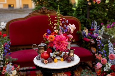 Beyaz masada meyve, çiçek ve antikalarla süslenmiş bir düğün.