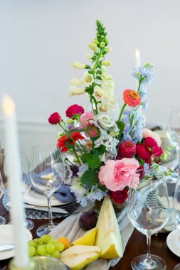 Beyaz masada meyve, çiçek ve antikalarla süslenmiş bir düğün.