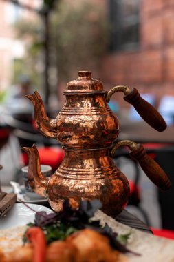 Türk geleneksel lale şeklindeki bardakta çay ve çift renkli çaydanlık