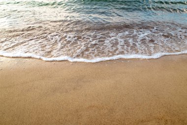 Kumlu sahilde denizin yumuşak dalgası