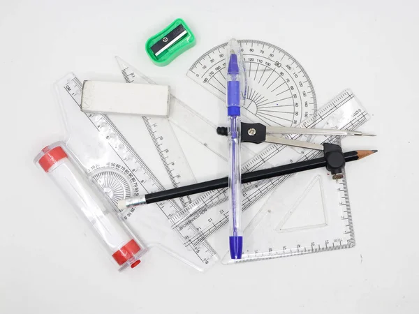 İletki, kare, cetvel, kalem, keskinleştirici, pusula ve silgi gibi geometrik çizim araçları beyaz bir arkaplanda izole edildi