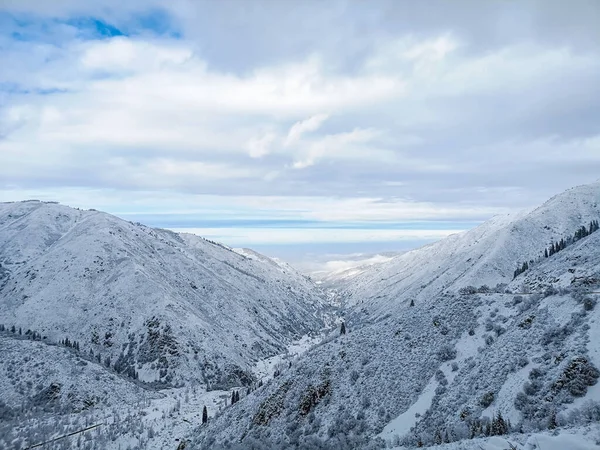 Zimní horská krajina proti modré obloze s mraky — Stock fotografie