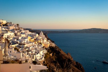 Batan güneşin ışınlarında Fira. Santorini, Yunanistan.