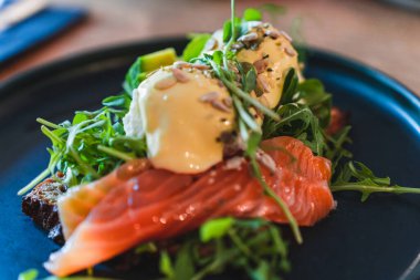 Tabaktaki kahvaltıya odaklan. Somonlu omlet, ayçekirdeği aromalı roka.