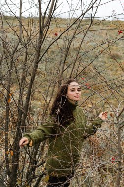 Hayalperest esmer genç kadın ağaçlarla çevrili ormanda duruyor. Doğa konsepti olan..