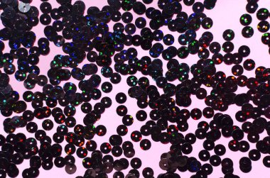 Pastel pembe arka planda siyah, ışıl ışıl pullar. Boşluğu kopyala.