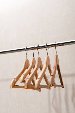 Boş elbise askıları beyaz arka planda bir alışveriş korkuluğunda asılı. Perakende, aşırı tüketim, moda, ikinci el konsept