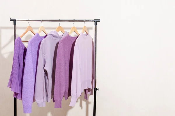 Fashionable tops in trendy purple, very peri, lavender colors hanging on a shopping rail. — 图库照片