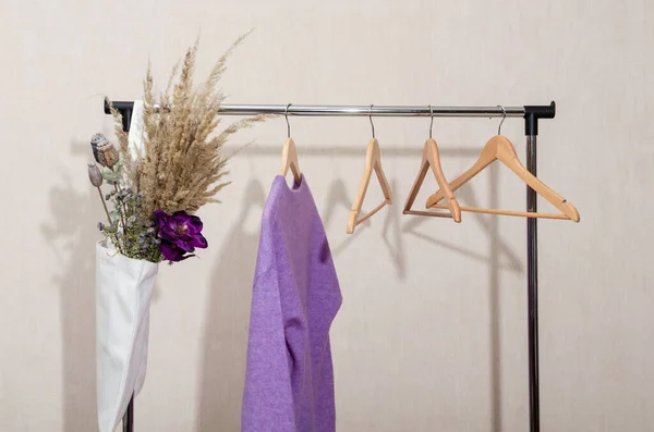 Ein Pullover in violettem Lavendel sehr peri Farben, Öko-Mehrwegbeutel und leere Kleiderbügel auf einer Schiene. Nachhaltige Mode. — Stockfoto