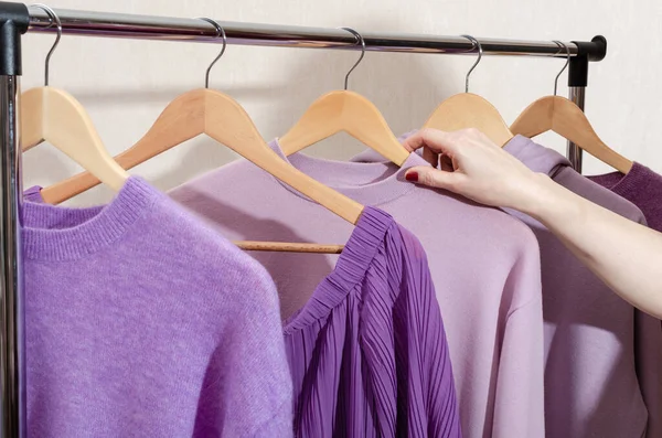 Stylist está escolhendo tops na moda em cores da moda no rack de roupas. Compras pessoais, conceito de sustentabilidade. — Fotografia de Stock