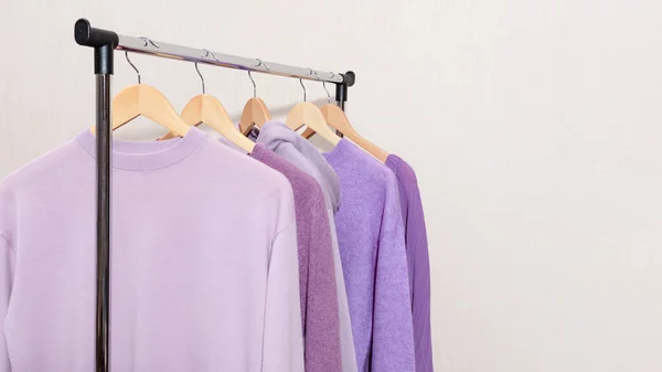 Fashionable tops in trendy purple, very peri, lavender colors hanging on a shopping rail. — 图库照片