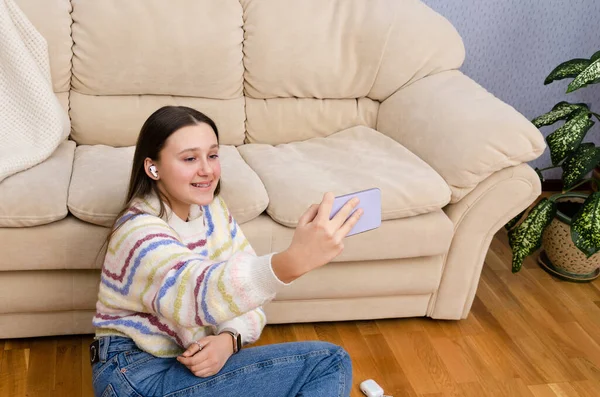 Boldog tizenéves lány használ okostelefon, videohívás, online streaming a közösségi média otthon. Z generációs befolyásoló tényezők. — Stock Fotó