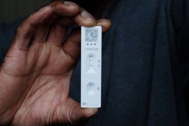 Siyah adam pozitif Coronavirus testi yapıyor.