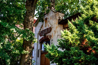 Polonya 'daki eski okul binası ağaçların arkasında.