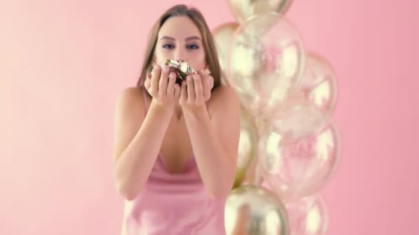 Первый взгляд на женщину, дующую конфетти — стоковое видео