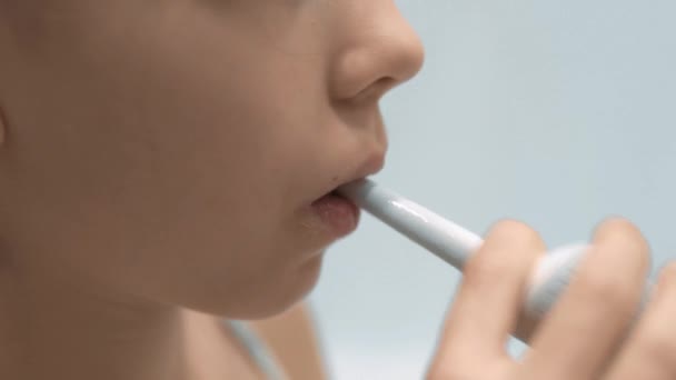 Closeup of Happy Girl fogmosás fogkefe segítségével elektromos fogkefe, elszigetelt fehér. A szájhigiénia és az egészséges életmód fogalma — Stock videók