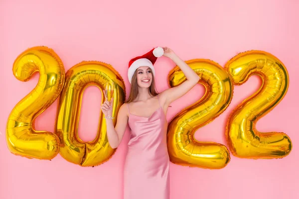 Sorrindo adulto menina segurar copo de champanhe em chapéu Santas 2022 balões de ar dourado conceito de Ano Novo — Fotografia de Stock