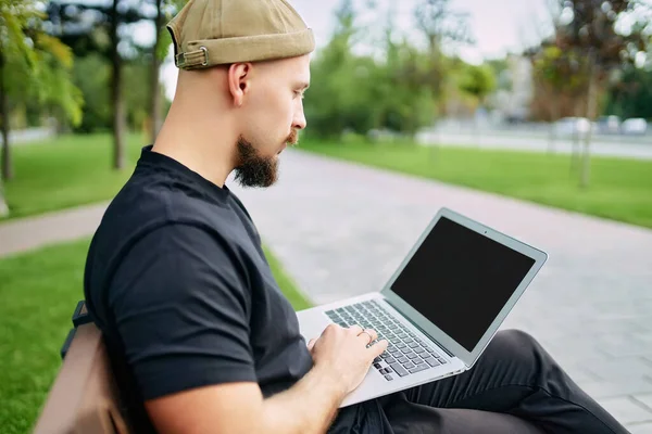 男人坐在长椅上工作 用笔记本电脑在屏幕上显示图形 图表和图表 网络营销 电子商务 证券交易 证券交易所 加密资产 — 图库照片