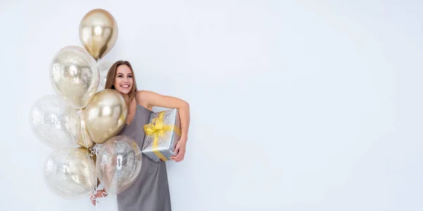 Foto de niña riendo mantenga grande envuelto caja de regalo y muchos globos de aire. vino a la fiesta. Celebración — Foto de Stock