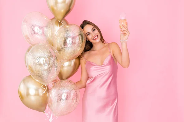 Zdjęcie cute girl podnosi kieliszek szampana posiada wiele balonów powietrza. Przyszedłem na imprezę. Świętowanie — Zdjęcie stockowe