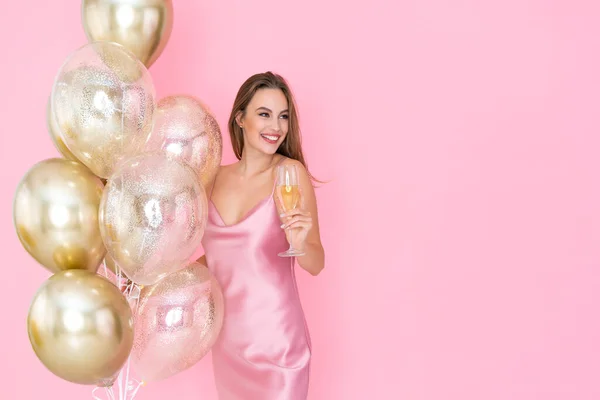 Erstaunlich lächelndes Mädchen hält ein Glas Champagner und viele Luftballons in der Hand. kam zum Feiern. Feier — Stockfoto
