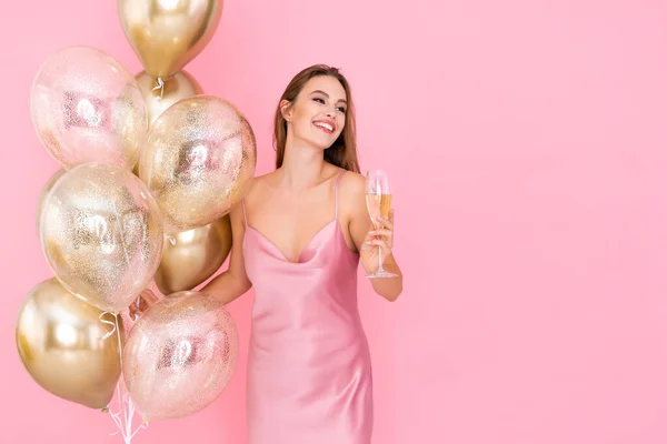 Chica sonriente riendo sostiene una copa de champán y muchos globos aéreos. vino a la fiesta. Celebración — Foto de Stock