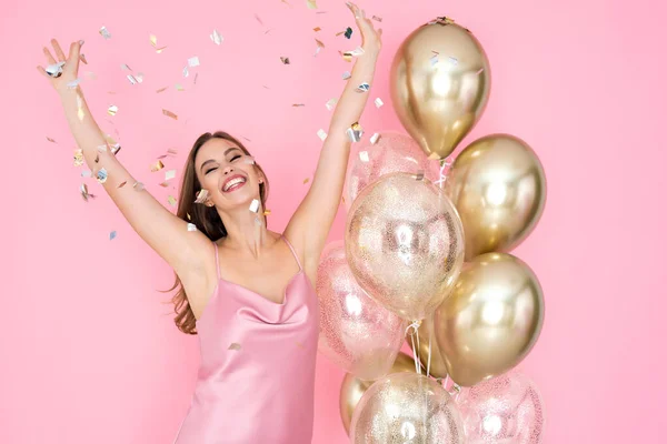 Feliz joven mujer celebra el Año Nuevo o la fiesta de cumpleaños feliz con globos de aire lanzando confeti. — Foto de Stock