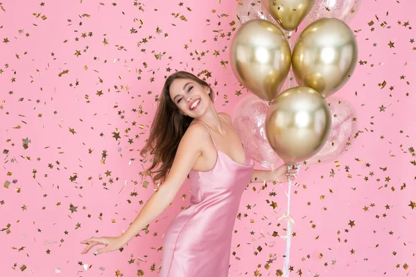 Happy Girl feiert Neujahr oder Happy Birthday Party mit Konfetti, während hält viele Luftballons — Stockfoto