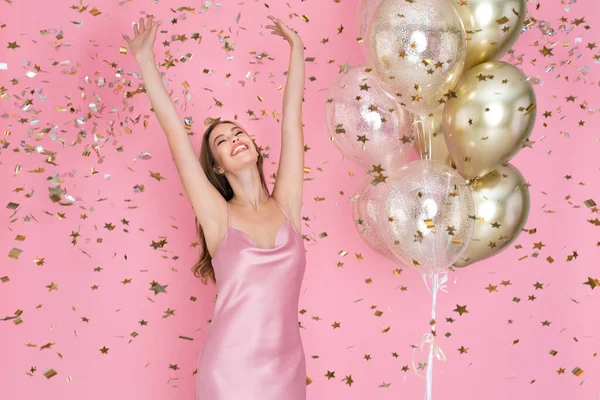 Érzelmi lány ünnepli szilveszter vagy boldog születésnapot party léggömbökkel dobott konfetti. — Stock Fotó