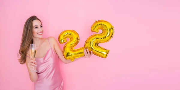Junges glückliches Mädchen hält Luftballon mit Goldfolie und ein Glas Champagner auf rosa Hintergrund BIRTHDAY PARTY — Stockfoto