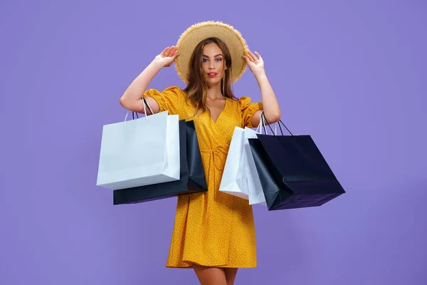 Fashion volwassen meisje houdt boodschappentassen op paarse achtergrond. verkoop, aankopen, winkelen, Black Friday — Stockfoto