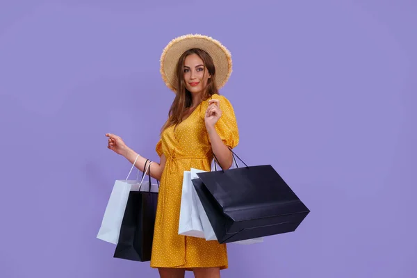 Divat nő tartja bevásárló táskák lila háttér. értékesítés, vásárlás, vásárlás, fekete péntek — Stock Fotó