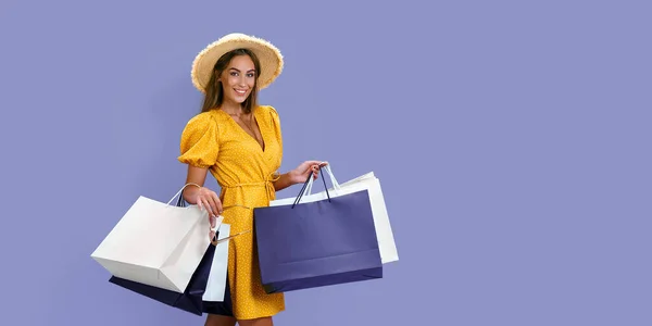 Divat mosolygós lány tartja csomagok vásárlás után lila háttér. Fekete péntek, nagy eladások — Stock Fotó