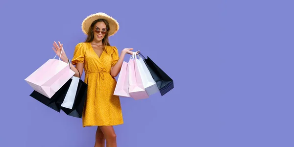 Mujer feliz en sombrero y gafas de sol lleva a cabo compras mientras sonríe a la cámara. Viernes Negro, grandes ventas —  Fotos de Stock