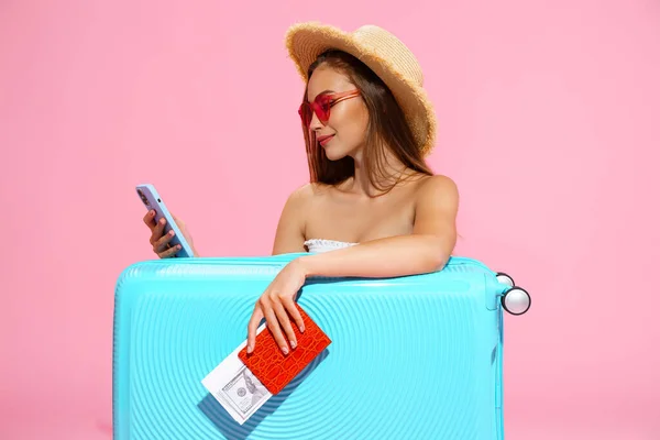 Pozitivní dívka s kufrem, letenkou, hotovostí a pasem bude cestovat. rezervace hotelu telefonicky — Stock fotografie