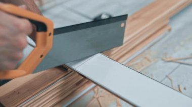 Tanımlanamayan marangozun ahşap bir tahtayı elle keserken yakın görüntüsü. Marangoz atölyesi