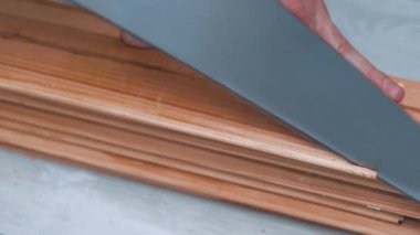 Tanımlanamayan marangozun ahşap bir tahtayı elle keserken yakın görüntüsü. Marangoz atölyesi