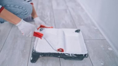 Plastik bir küvetten boya toplayan bir patencinin yakın çekimi. Ev yenileme ve yenileme konsepti