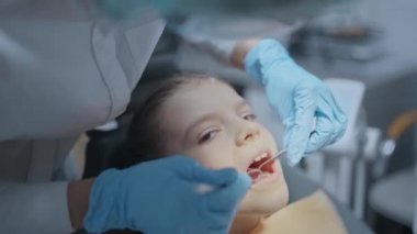 Diş kontrolü sırasında ağzı açık olan küçük bir kızın yüzünü kapatın diş ağrısı sırasında.. 