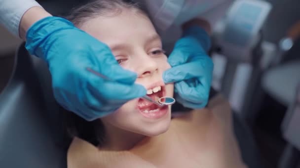 Gros plan sur le visage d'un enfant patient courageux à bouche ouverte pendant le contrôle dentaire prévention des maux de dents. — Video