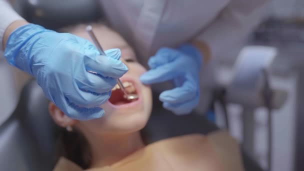 Primer plano de la cara de paciente valiente chica con la boca abierta durante el control dental prevención dolor de muelas — Vídeos de Stock