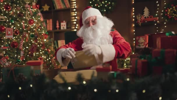 感情用事的圣诞老人或圣尼古拉斯紧紧抓住他的头，打开装有圣诞祝福的信封 — 图库视频影像