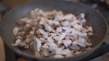 Mantar parçaları tavada kızartılır. Dilimlenmiş şampiyonlar, yağda kızartılmış.